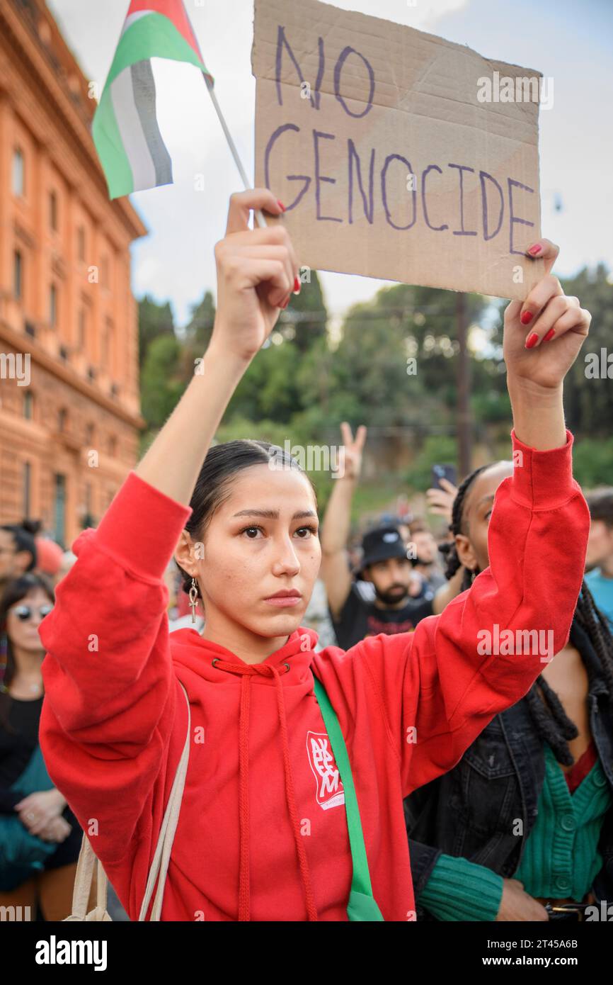 Roma, Italia. 28 ottobre 2023. Una donna palestinese dagli occhi lacrimi sorregge il segno con le parole "no genocide” durante la manifestazione a sostegno del popolo palestinese a Roma. La manifestazione nazionale organizzata dalle associazioni palestinesi in Italia a sostegno della lotta del popolo palestinese ha visto la partecipazione di circa 20 mila persone gente, secondo la sede di polizia, proveniente da tutta Italia per ribadire il diritto all'autodeterminazione del popolo palestinese e chiedere al governo italiano di condannare il "tentativo di pulizia etnica e il mostruoso r Foto Stock