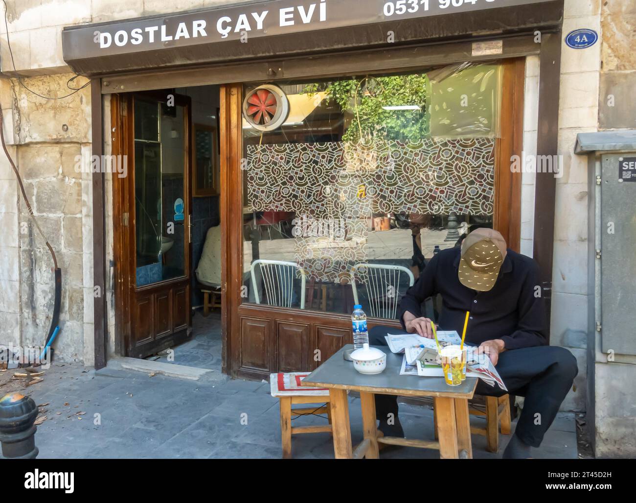 Gaziantep Turkey: Uomo che legge il giornale nella tradizionale casa da tè, chai Diner, chai Cafe' con tavoli all'aperto. Foto Stock