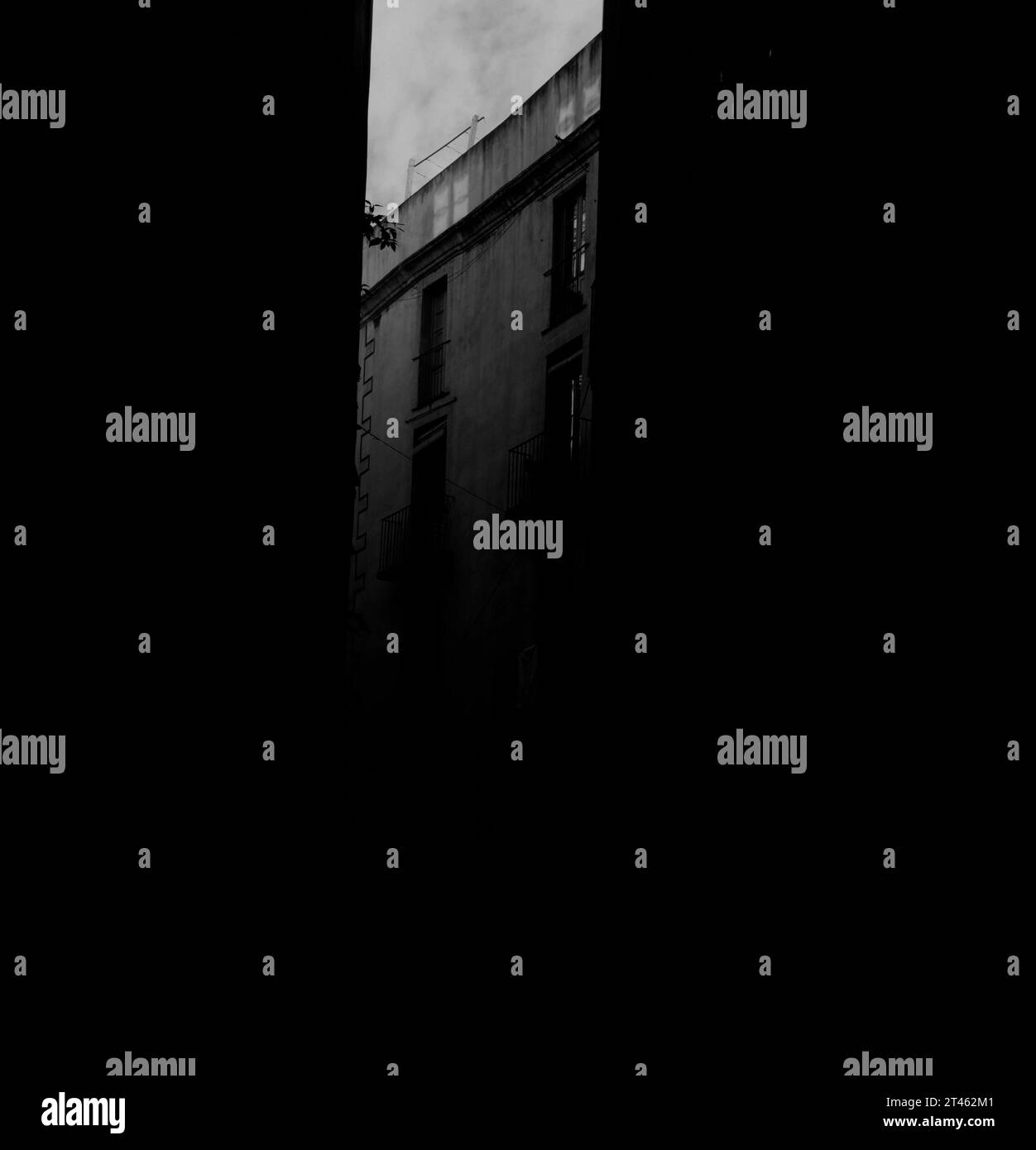 Quartiere Raval in bianco e nero che mostra le ultime due finestre dell'attico di un edificio. Nella foto potete vedere una piccola parte del cielo. Foto Stock