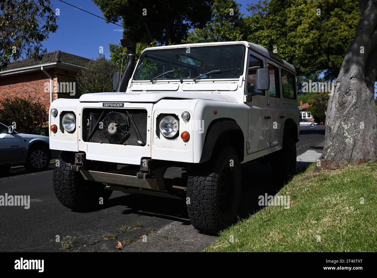 Vecchia Land Rover Defender bianca, parzialmente restaurata, parcheggiata in una strada suburbana di Melbourne durante una giornata di sole Foto Stock