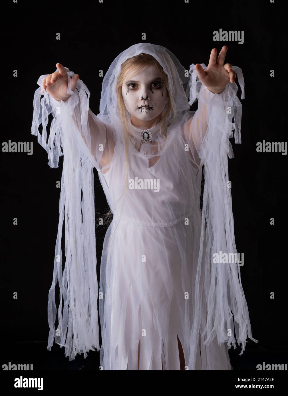 Bambina in costume fantasma di Halloween che cammina su di te, studio isolato su sfondo nero Foto Stock
