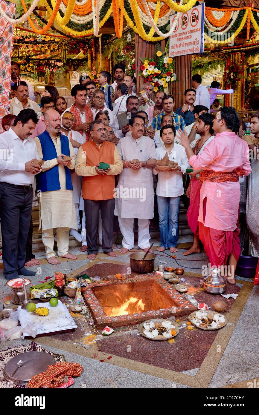 In occasione del 'compleanno' della dea Mumbadevi, invitati V.I.P. partecipano ad un rituale del fuoco; al Tempio Mumbadevi, Mumbai, India Foto Stock