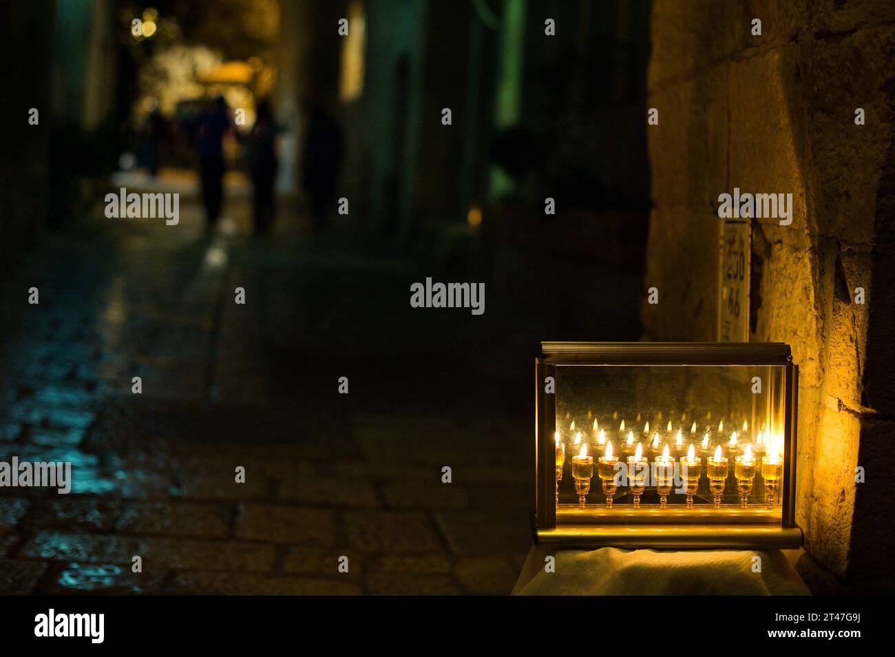 Le fiale di vetro contengono olio e stoppini brucianti in una menorah che si illumina in una strada di Gerusalemme l'ottava notte del festival ebraico di Hanukkah. Foto Stock