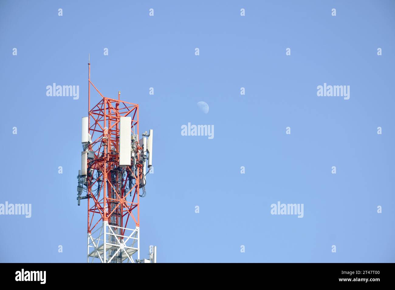 palo di telecomunicazione con mezza luna su nuvola e cielo nelle giornate di sole Foto Stock