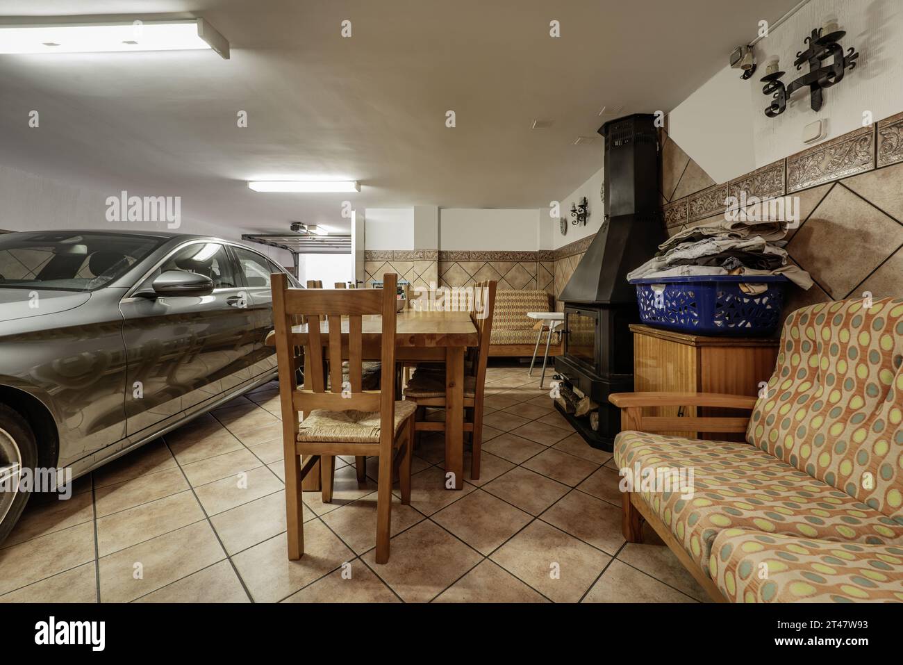 Garage di una casa unifamiliare con spazio per una sala da pranzo con un tavolo rustico in legno Foto Stock