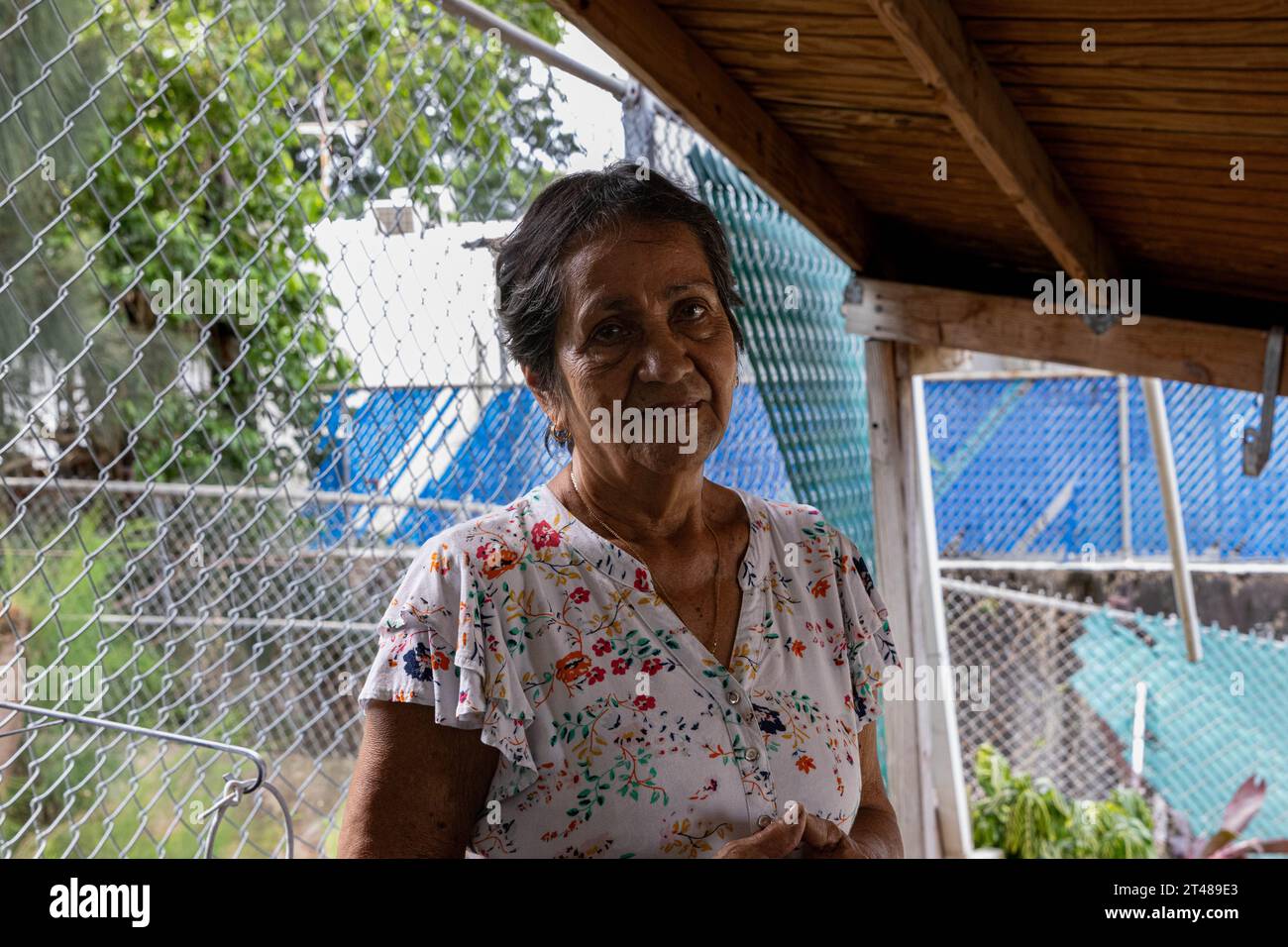 San Juan, Stati Uniti. 28 ottobre 2023. Hayde Vélez si trova sul suo ponte di cemento distrutto nel quartiere del reparto Metropolitano di San Juan, Porto Rico, 28 ottobre 2023. Piogge da record colpirono San Juan durante la notte, causando pesanti inondazioni. Velez se ne andò non appena la gola adiacente iniziò a crescere e tornò durante il giorno per scoprire che il suo cortile era affondato nel burrone. (Foto di Carlos Berríos Polanco/Sipa USA) credito: SIPA USA/Alamy Live News Foto Stock