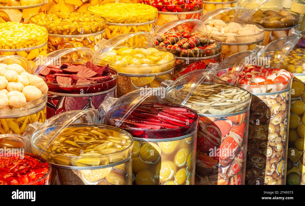 Grandi vasetti di vetro con verdure sott'aceto di diversi colori, come barbabietole, aglio e peperoni. Foto Stock