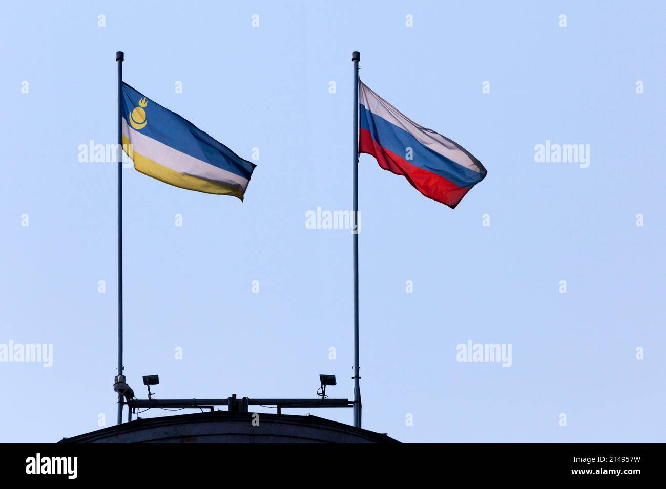 Bandiera della Repubblica di Buryatia accanto alla bandiera della Federazione di Russia che sventola in cima a un edificio. Foto Stock