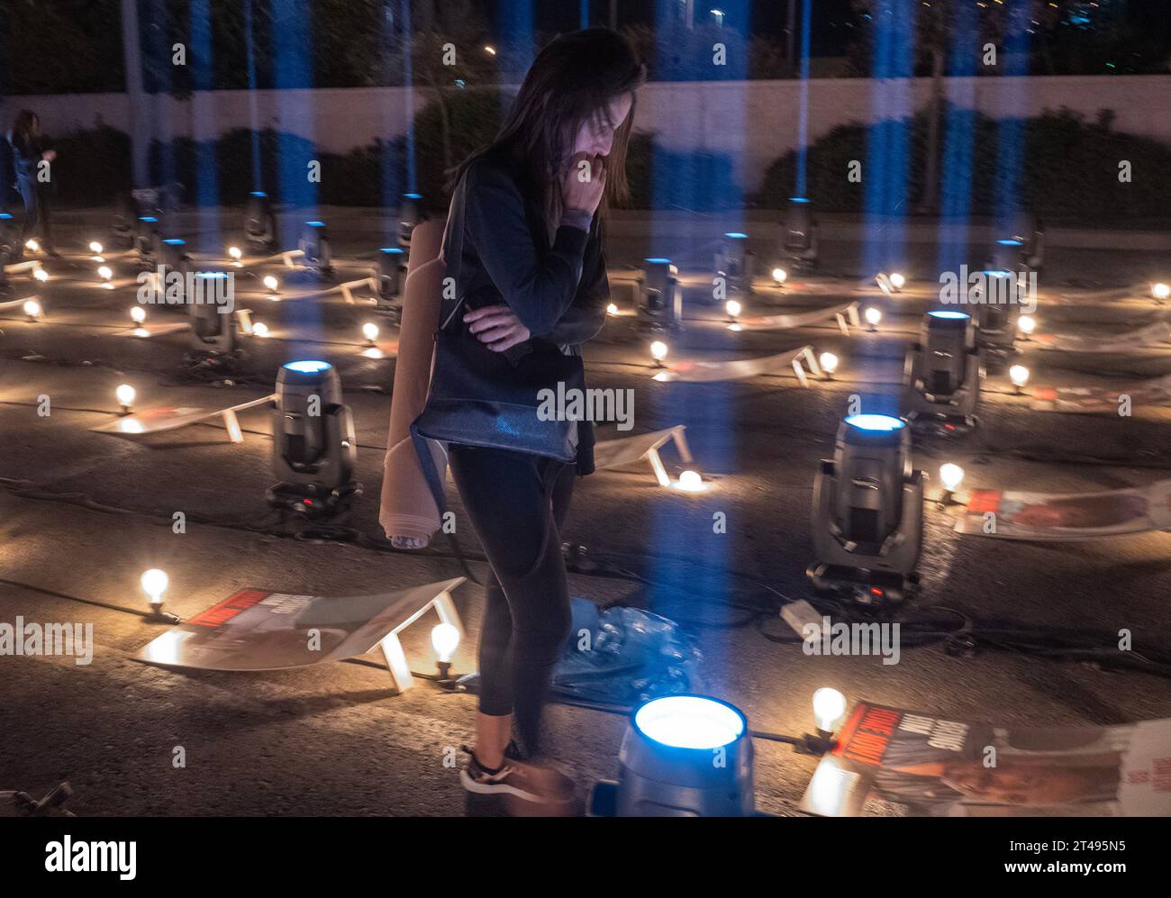 Gerusalemme, Israele. 29 ottobre 2023. Una donna israeliana guarda i poster di alcuni dei 229 israeliani tenuti in ostaggio da Hamas all'interno della Striscia di Gaza in una veglia serale tenuta fuori da uno stadio sportivo nel sud di Gerusalemme il 29 ottobre 2023. La veglia ha ritratti di tutti gli ostaggi disposti in una terrazza e sarà illuminata ogni notte fino a quando gli ostaggi presi il 7 ottobre 2023 durante l'attacco terroristico di Hamas non saranno rilasciati. Foto di Jim Hollander/UPI Credit: UPI/Alamy Live News Foto Stock