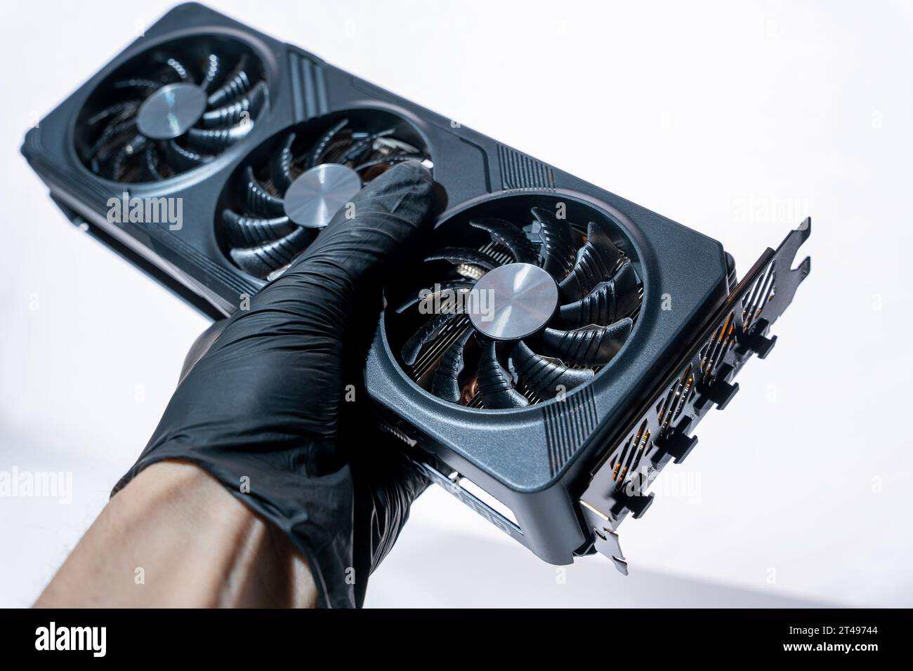 la mano di un tecnico informatico contiene una potente e moderna scheda per videogiochi per un computer con tre fan. Il concetto di hardware per PC. Video car di gioco Foto Stock