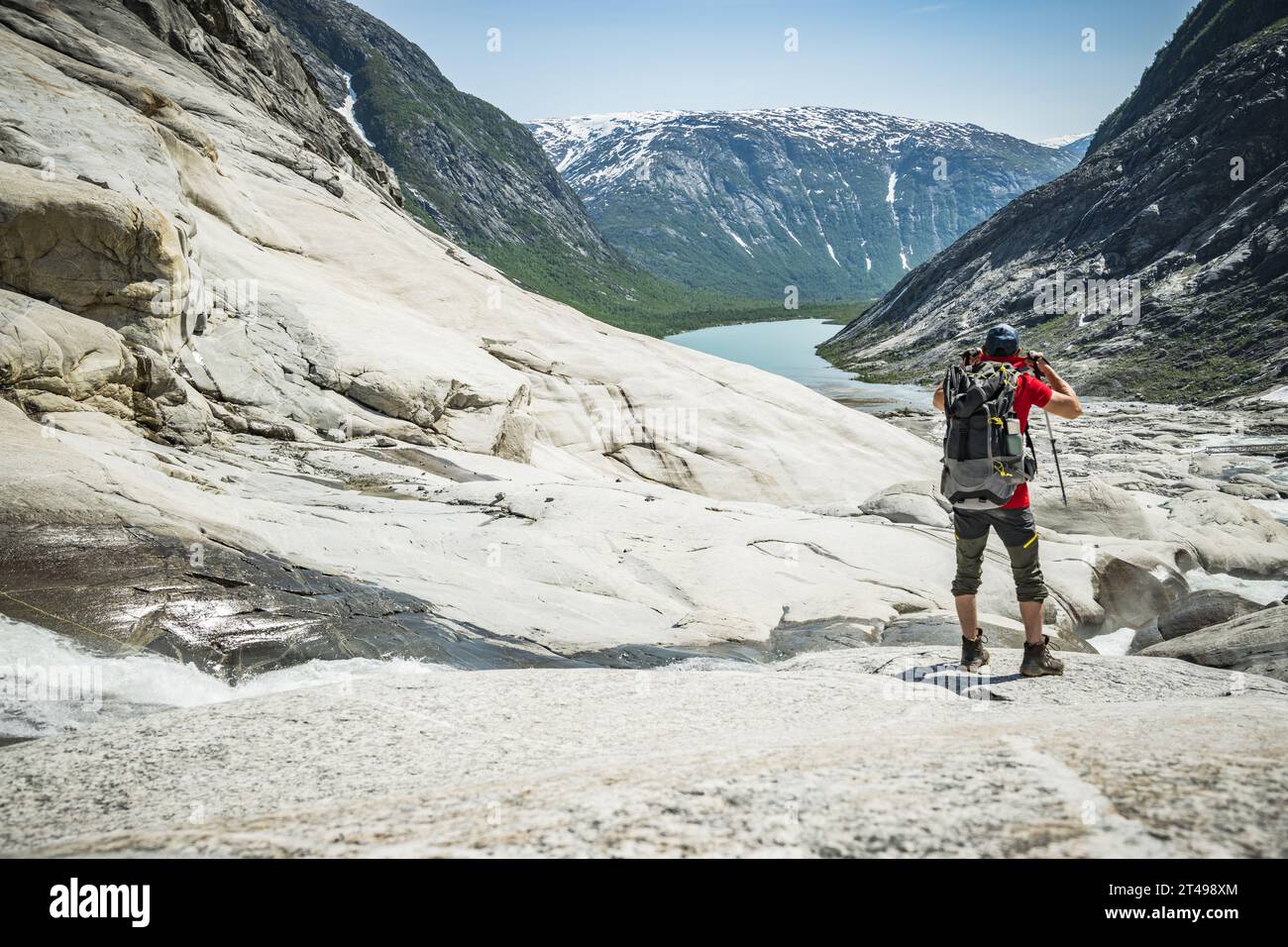 Escursionista caucasico nel paesaggio glaciale norvegese. Sentieri norvegesi estivi. Foto Stock