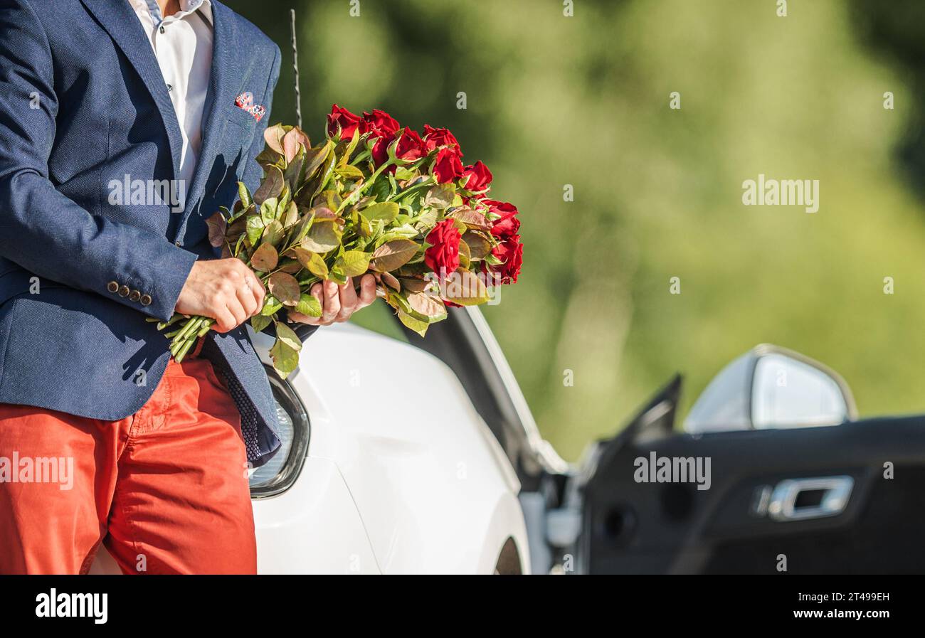 Giovane gentiluomo con Red Roses in mano in attesa della sua fidanzata durante San Valentino Foto Stock