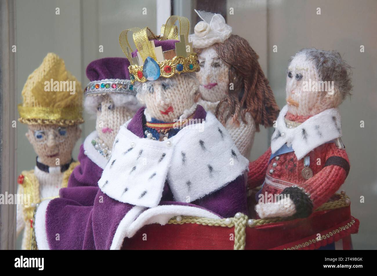 Bambole lavorate a maglia a mano di re Carlo III e membri della famiglia reale esposte, su un davanzale, per celebrare la sua incoronazione nel 2022. Inghilterra, Regno Unito. Foto Stock