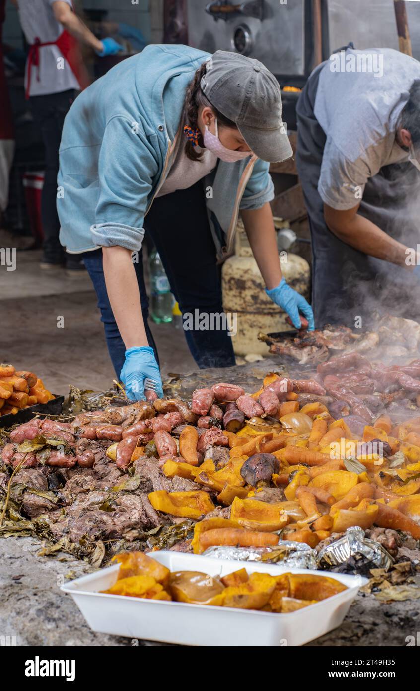 COLONIA SUIZA, SAN CARLOS DE BARILOCHE, ARGENTINA - 10 NOVEMBRE 2021: Un gruppo di cuochi raccoglie la carne e le verdure preparate sottoterra come parte Foto Stock