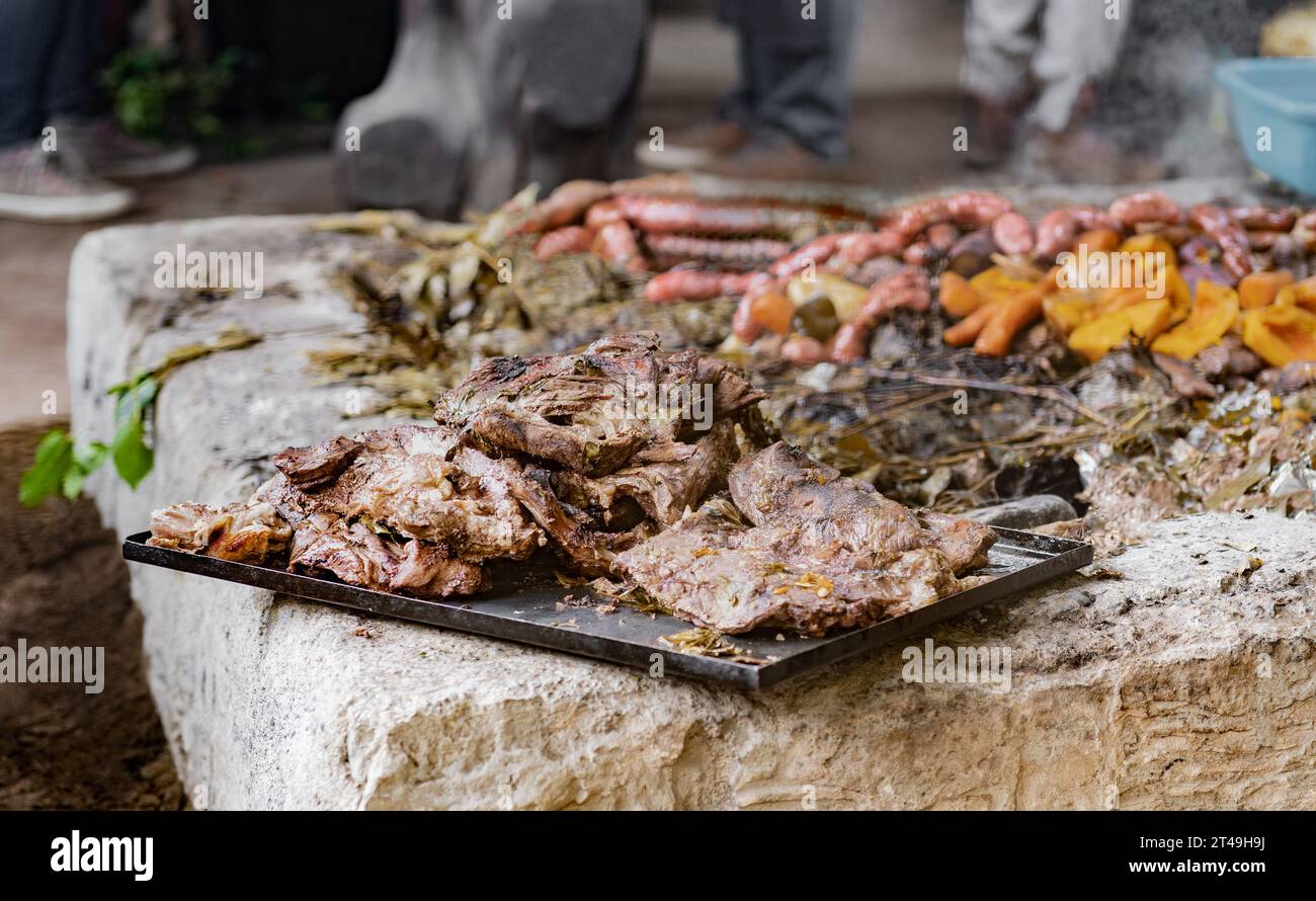 Un vassoio con carne preparata sottoterra come parte della cerimonia del curanto, un cibo tradizionale della Patagonia. Colonia Suiza, Bariloche, Argentina. Foto Stock