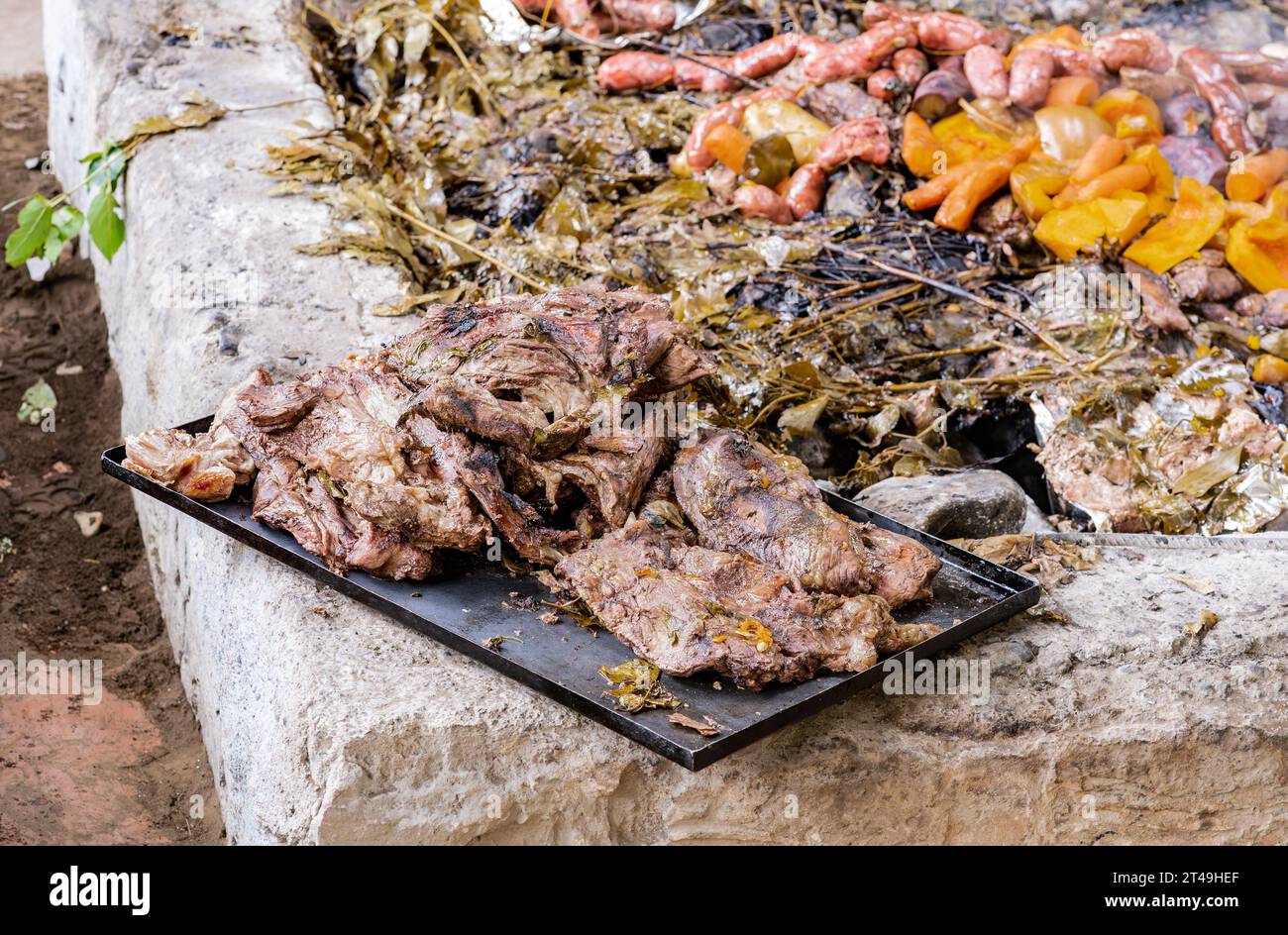 Un vassoio con carne preparata sottoterra come parte della cerimonia del curanto, un cibo tradizionale della Patagonia. Colonia Suiza, Bariloche, Argentina. Foto Stock