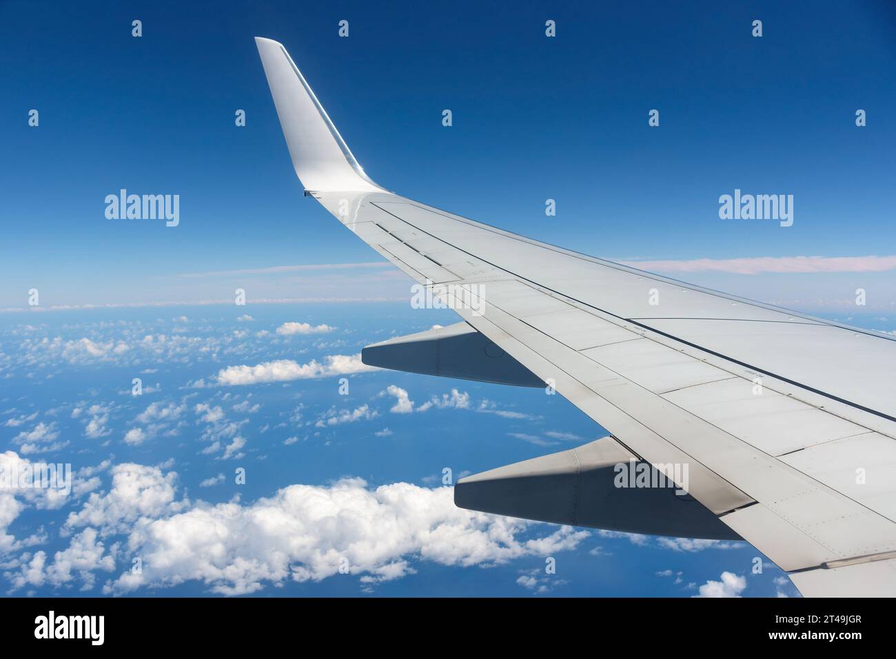 Ala dell'aereo contro il cielo blu vista dalla sua finestra Foto Stock