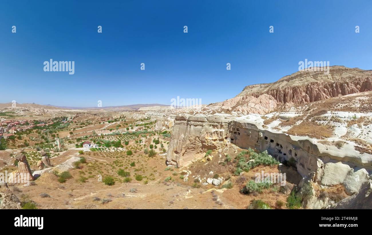 Annidato in Cappadocia, Turchia, il villaggio di Cavusin incanta con il suo fascino antico e le sue meraviglie naturali. Delicate dimore rupestri e storiche case in pietra Foto Stock
