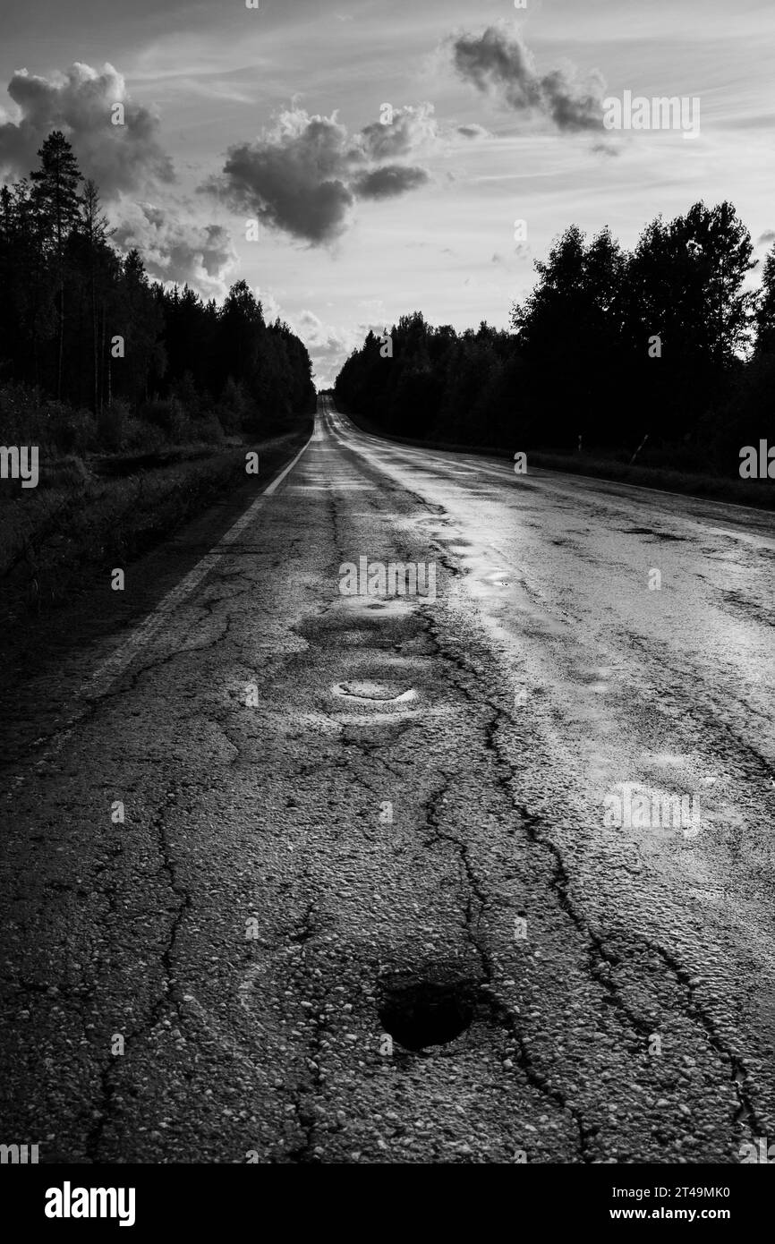 Una buche su una strada di campagna bagnata in estate tempestosa nella regione di Kajaani, nella Finlandia centrale. Foto: Rob Watkins Foto Stock