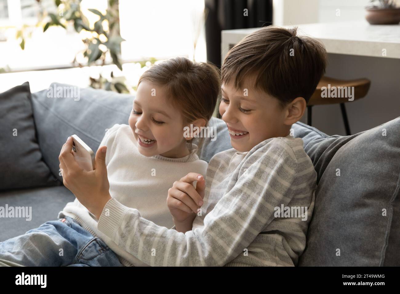 Eccita i bambini piccoli della generazione Z che usano insieme lo smartphone Foto Stock