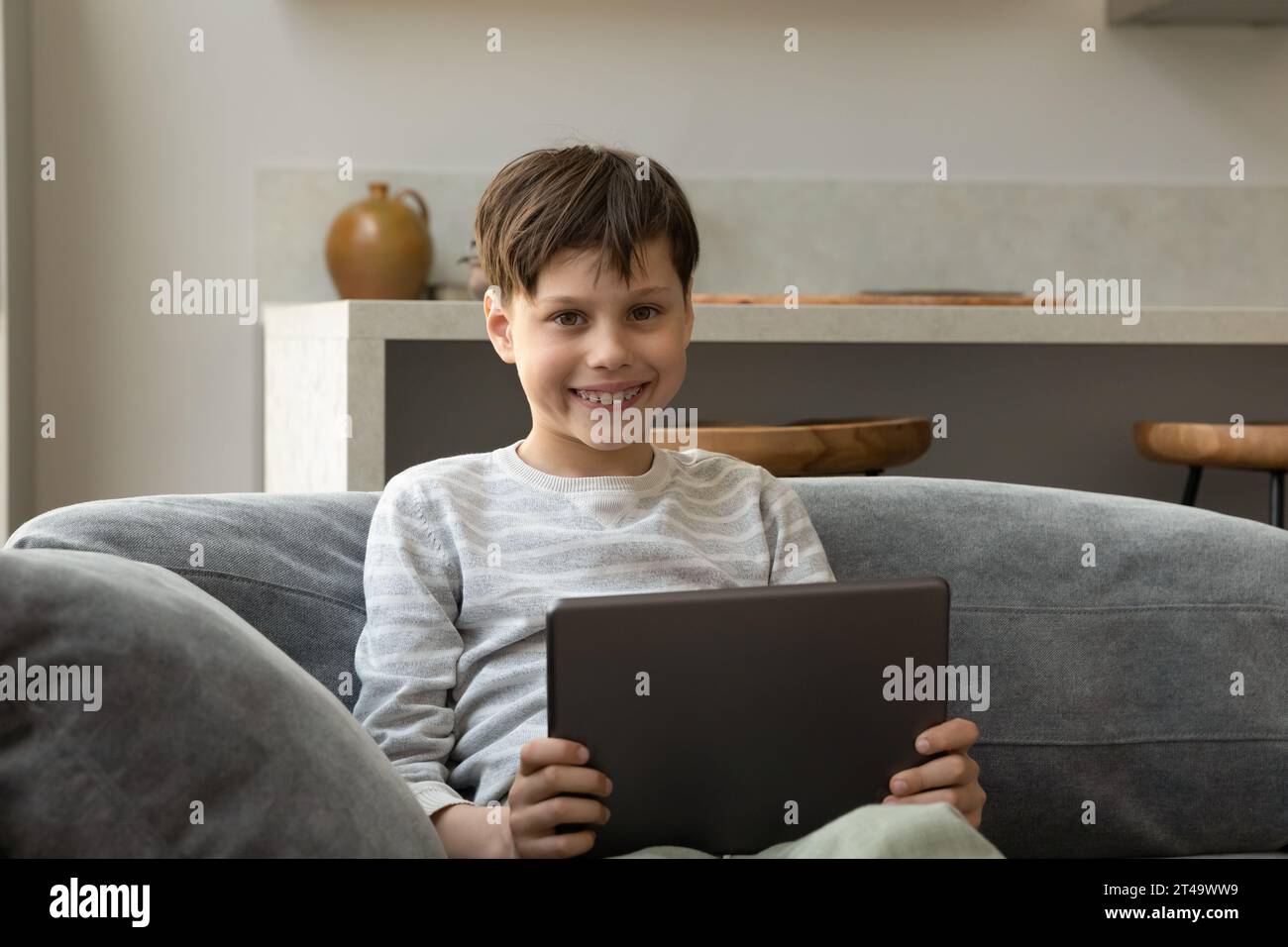 Felice ragazzo adolescente di generazione Z che usa un tablet Foto Stock