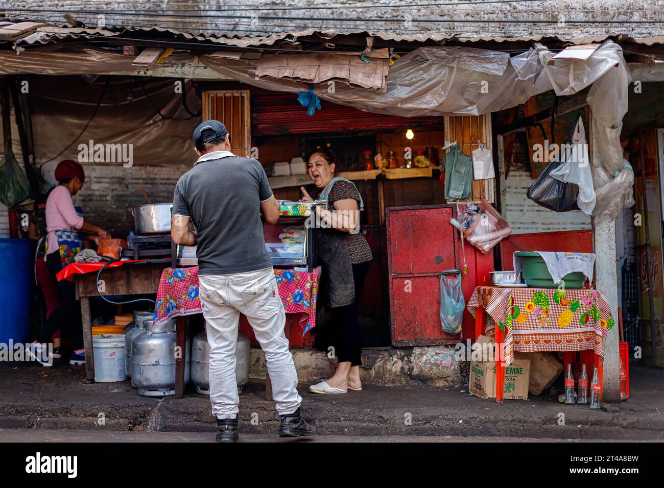 Ciudad del Este, Paraguay - 27 luglio 2022: L'uomo compra in una bancarella di Street food all'interno dell'area commerciale Foto Stock