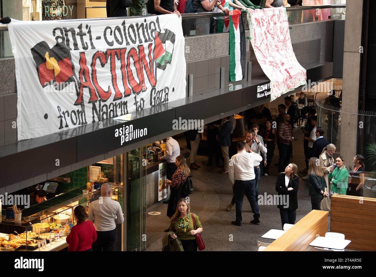 Melbourne, Australia. 30 ottobre 2023, Melbourne, Australia. Un passante sotto guarda gli striscioni pro-Palestina, tenuti al secondo piano di Collins Place mentre i manifestanti organizzano una manifestazione pubblica rapida, mirata specificamente al Dipartimento degli affari Esteri e del commercio. Crediti: Jay Kogler/Alamy Live News Foto Stock