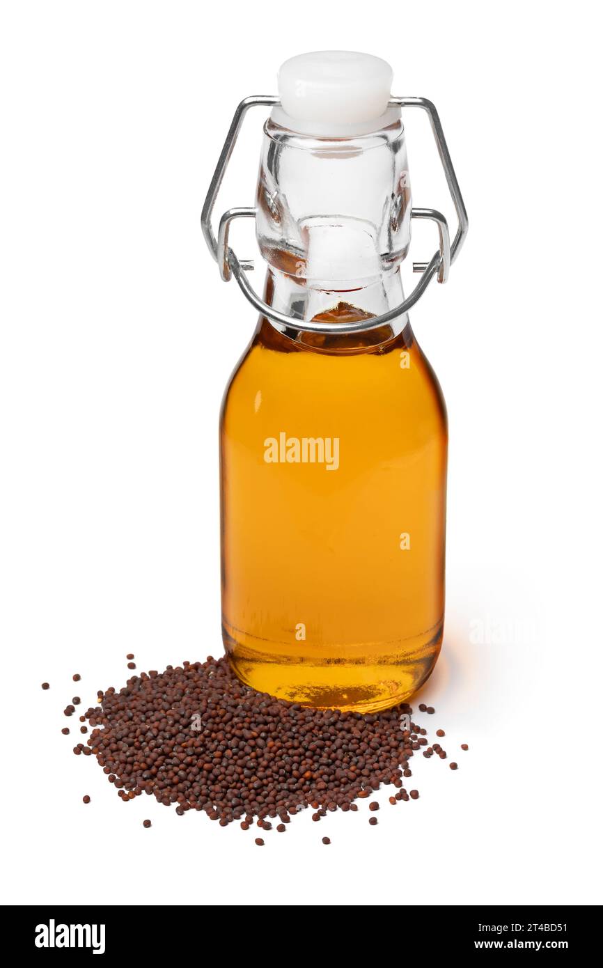 Bottiglia con olio di senape marrone e semi di senape nera nella parte anteriore isolati su sfondo bianco da vicino Foto Stock