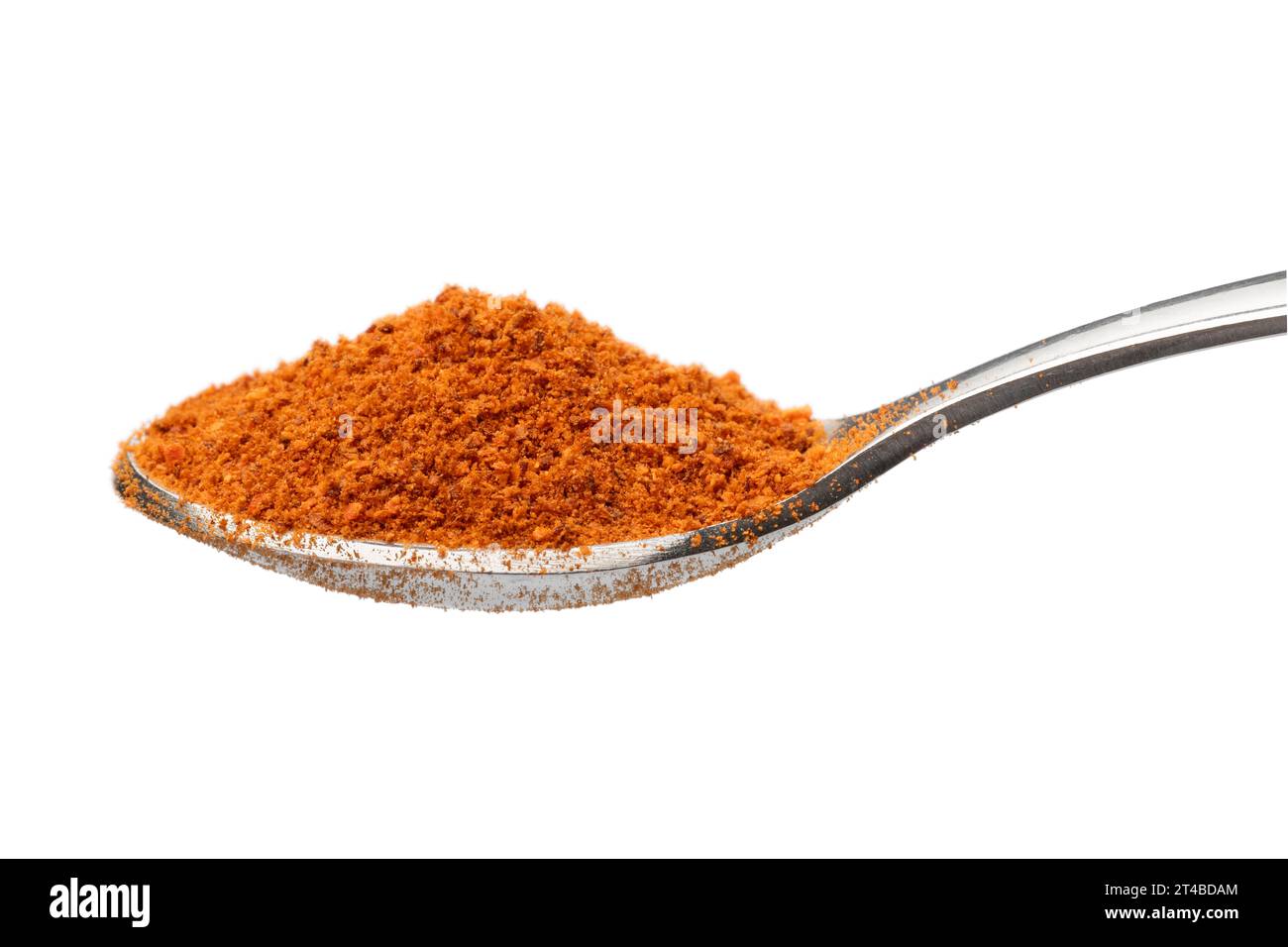 Cucchiaio singolo in metallo con polvere di peperoncino caldo macinato su sfondo bianco in primo piano Foto Stock