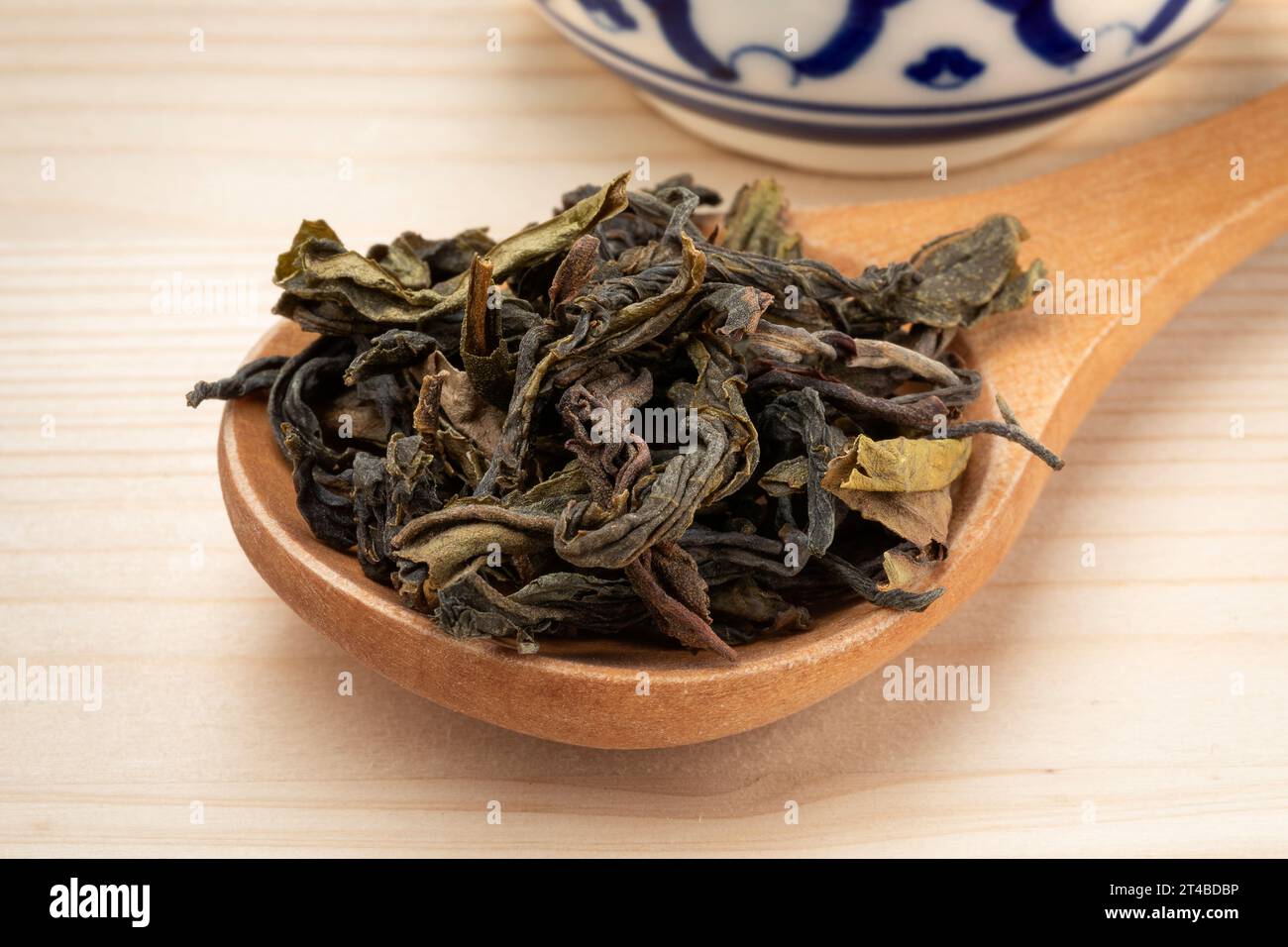 Le foglie di tè essiccate Thai Choui Fong si chiudono su un cucchiaio di legno Foto Stock
