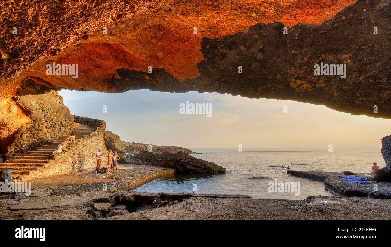 Spiaggia Sataria, luce serale, grotta sul mare, scale, vista esterna, persone Pantelleria, isole pelagiche, Sicilia, Italia Foto Stock
