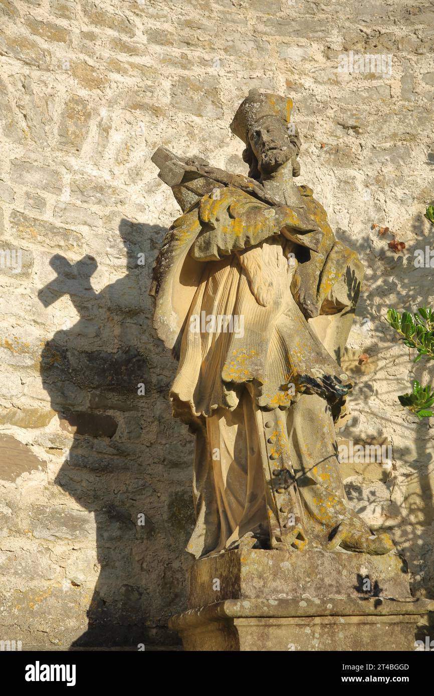 Scultura di Giovanni Nepomuceno presso il monastero romanico di Comburg, ex monastero benedettino, santo con croce e ombra, pietra, medievale Foto Stock