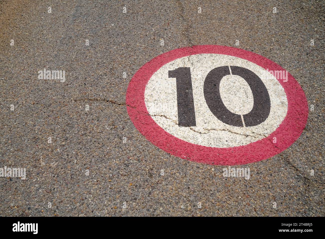 10 segnale del limite di velocità verniciato su asfalto asfaltato stradale Foto Stock