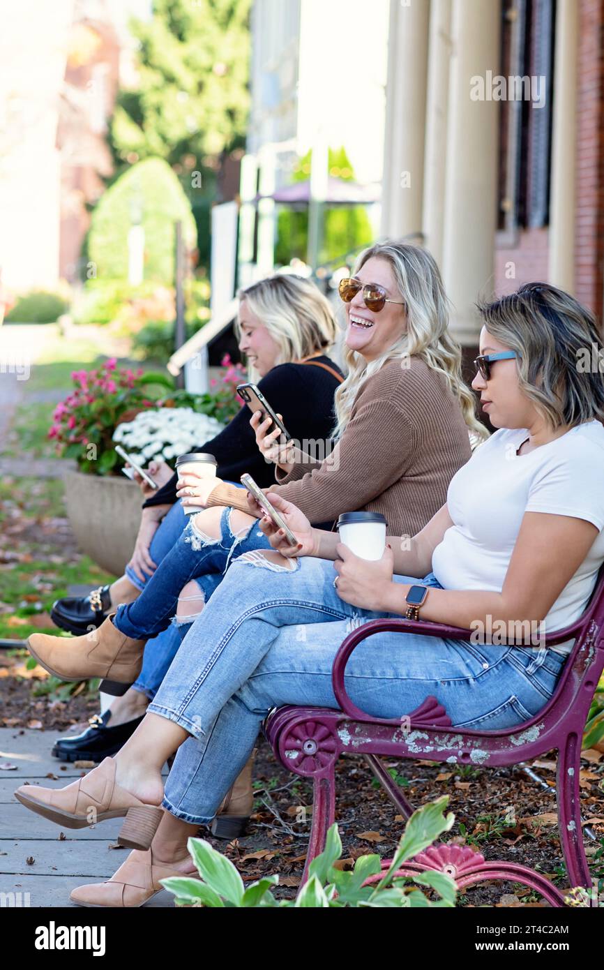 Immagine verticale di donne sui telefoni e che bevono caffè Foto Stock