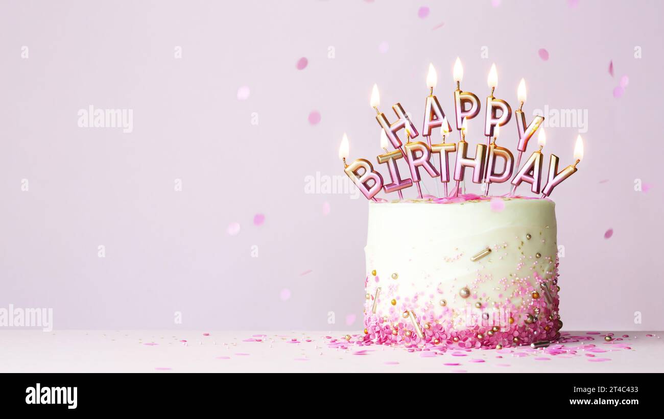 Torta di compleanno con candele di compleanno rosa e dorate che scrivono buon compleanno su sfondo rosa Foto Stock