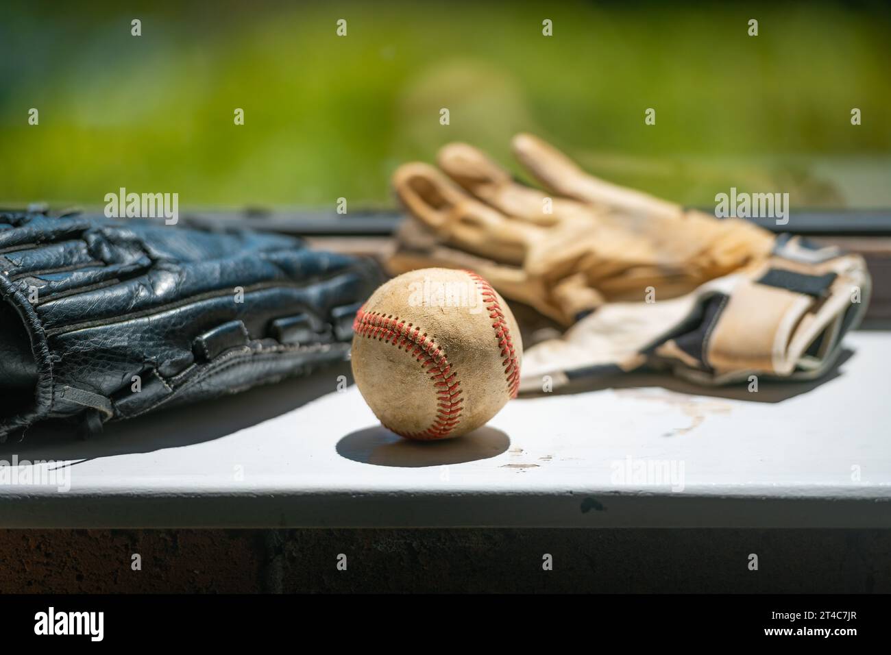 Vecchia palla da baseball, guanti e guanti da battuta seduti sulla sporca davanzale con spazio per le copie Foto Stock