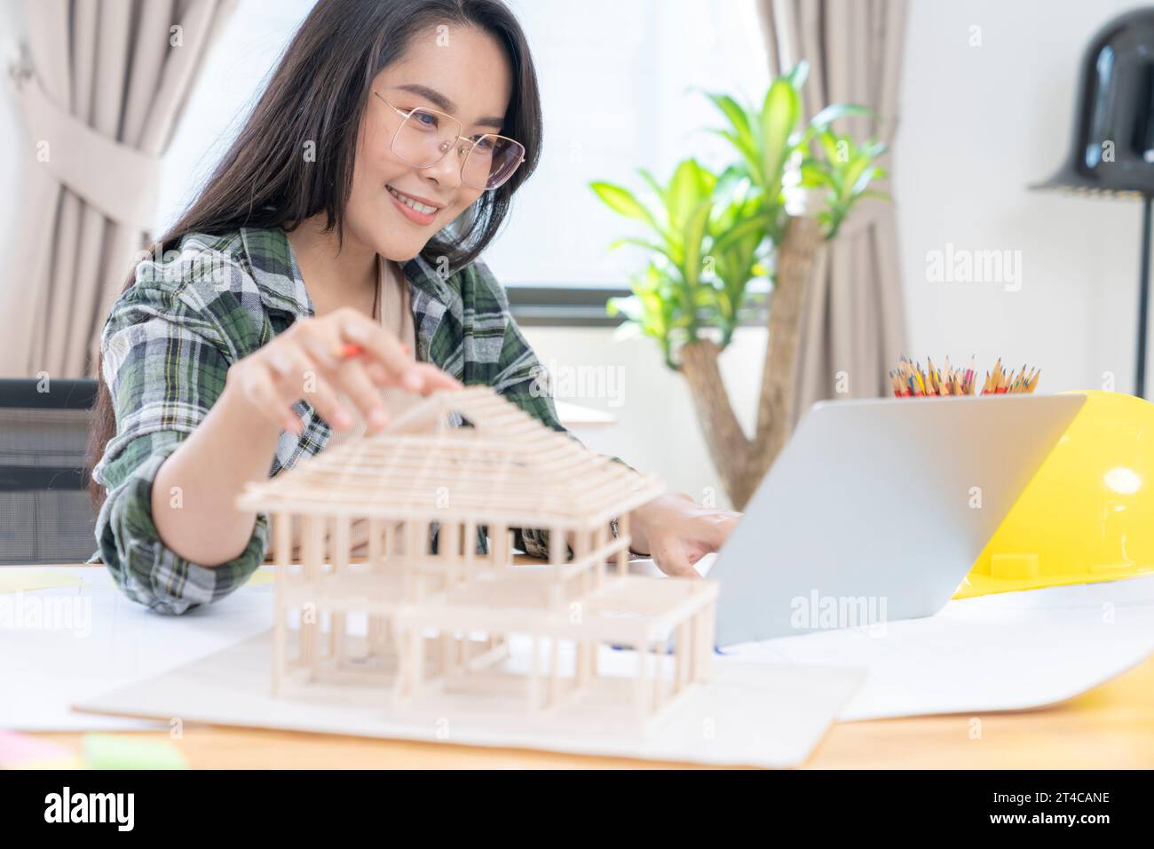 Architetti che lavorano su un modello di casa in un ufficio creativo. Foto Stock