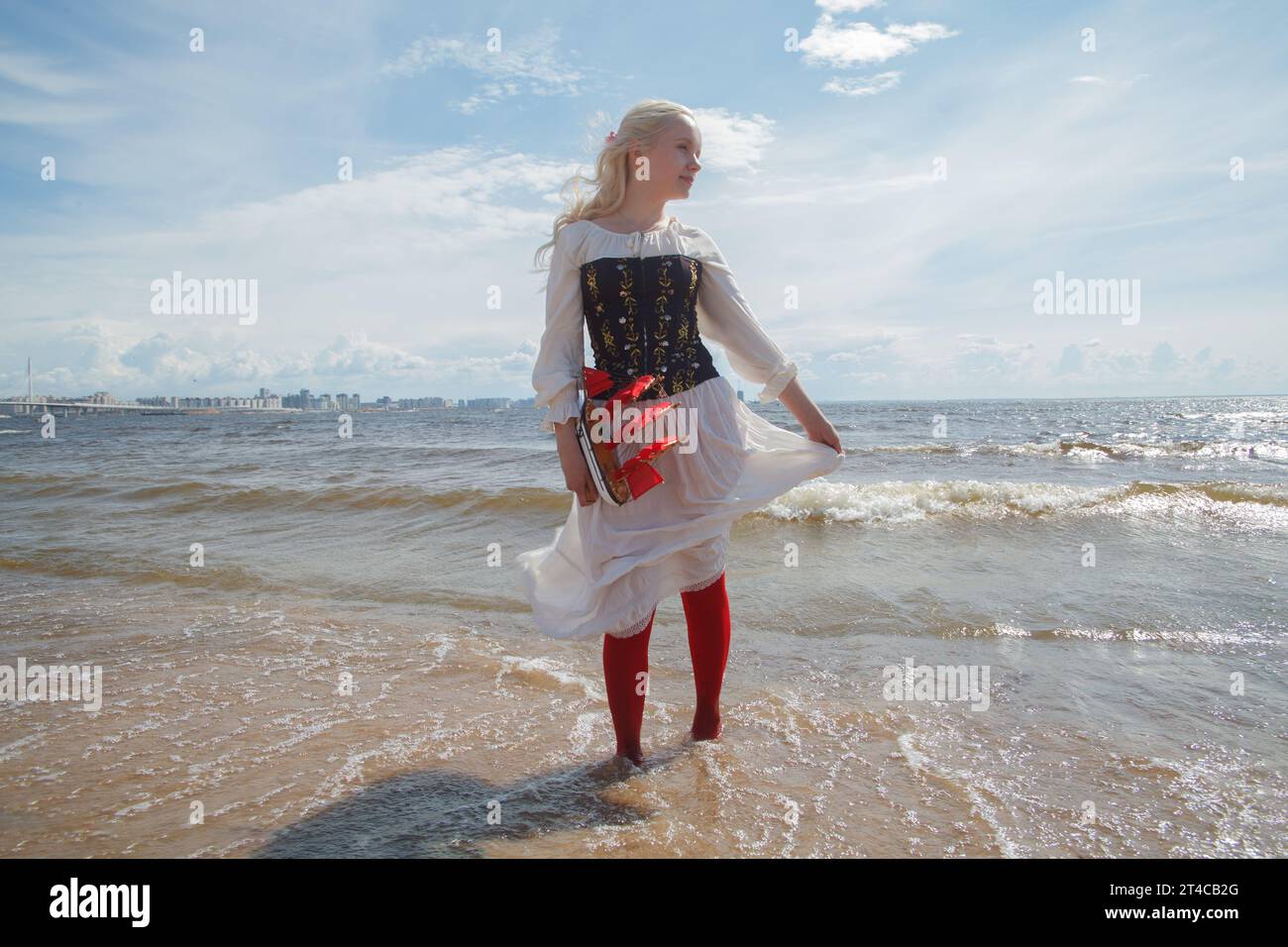 Giovane modella bionda in piedi sulla spiaggia di mare, ritratto romantico Foto Stock