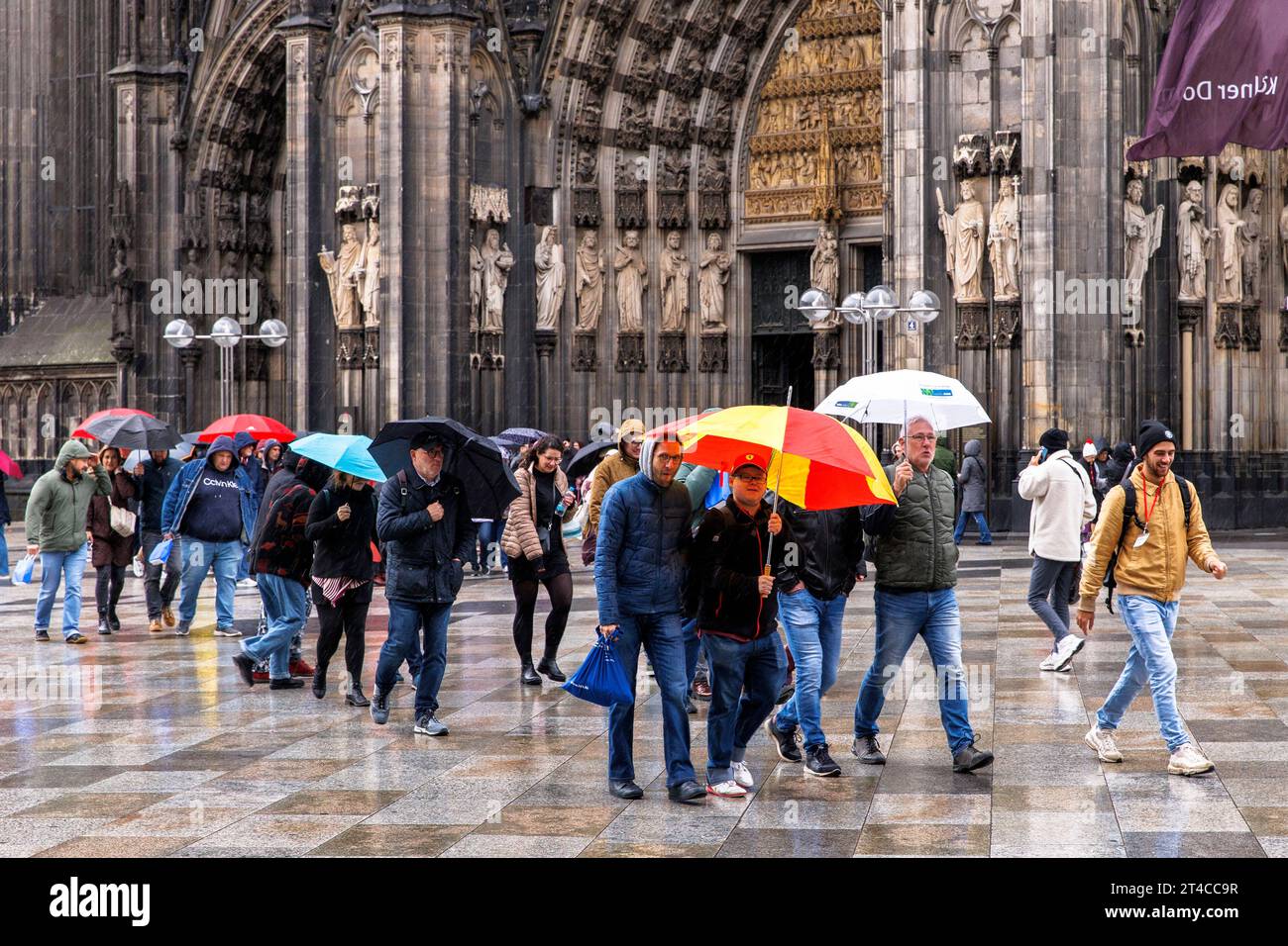 Persone che camminano sotto la pioggia su piazza Domplatte di fronte alla cattedrale, Colonia, Germania. Menschen gehen bei Regen ueber die Domplatte, Koeln, Deu Foto Stock