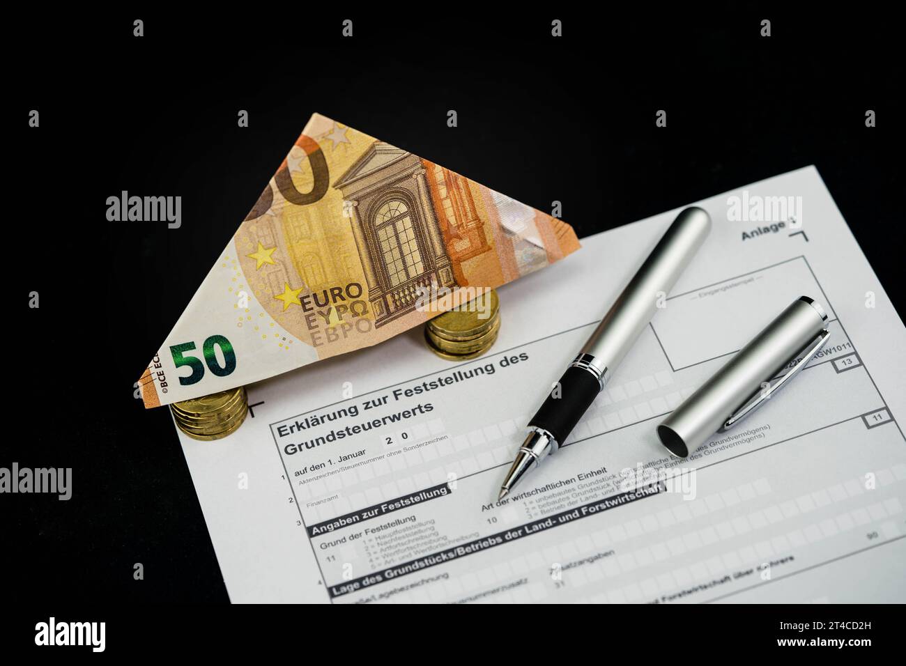 Documento sulla tassa fondiaria con banconota da 50 euro piegata e penna a sfera Foto Stock