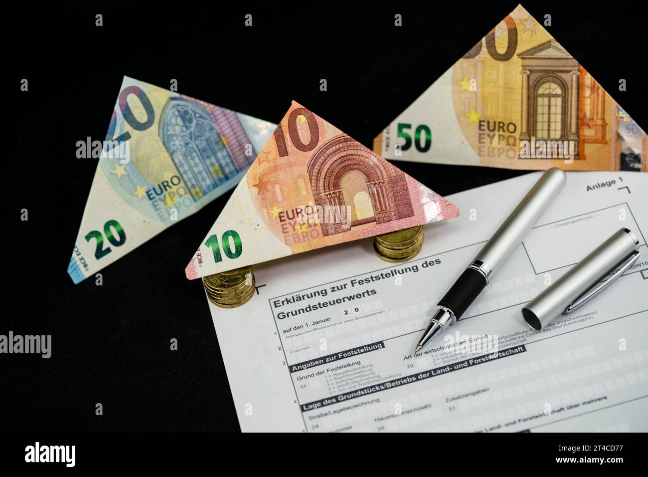 Documento sulla tassa fondiaria con banconote in euro piegate e penna a sfera Foto Stock