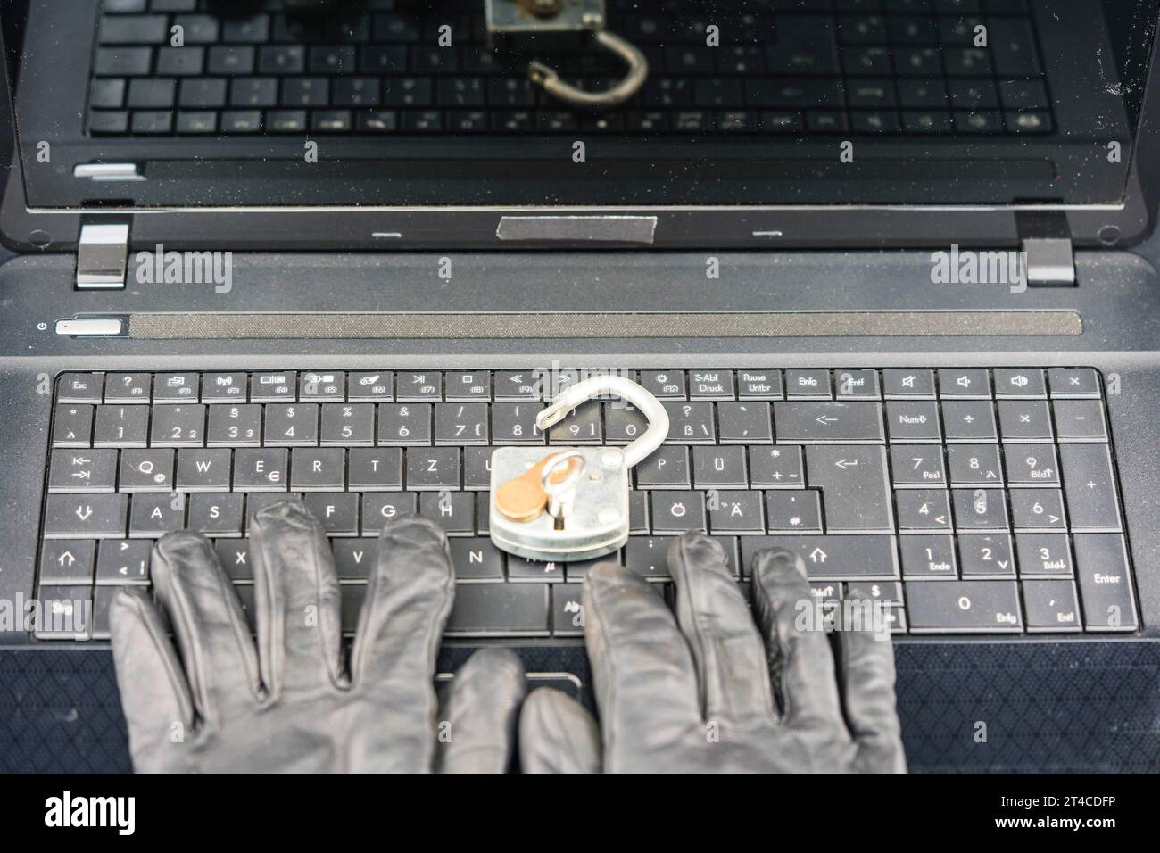 mani con guanti che digitano sulla tastiera del computer portatile con blocco di sicurezza, privacy, furto di dati Foto Stock