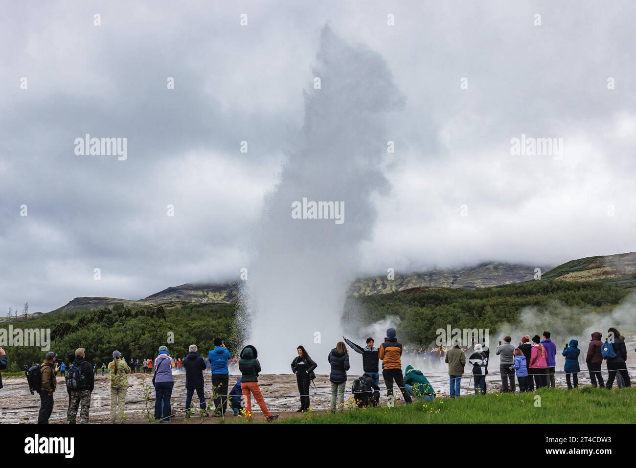 Turisti umili che guardano il geyser in eruzione Strokkur, Islanda, Haukadalur Foto Stock