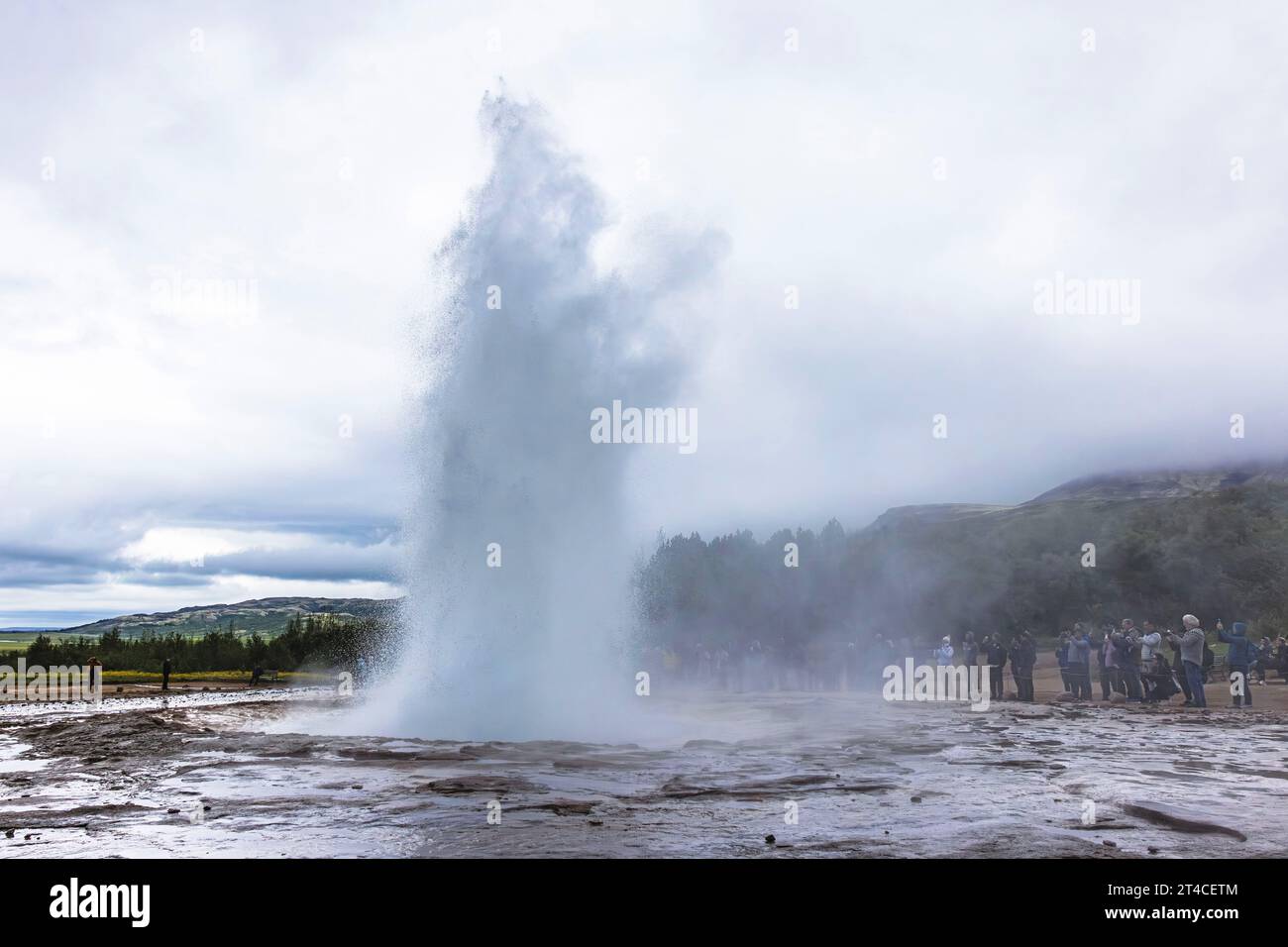 Turisti umili che guardano il geyser in eruzione Strokkur, Islanda, Haukadalur Foto Stock