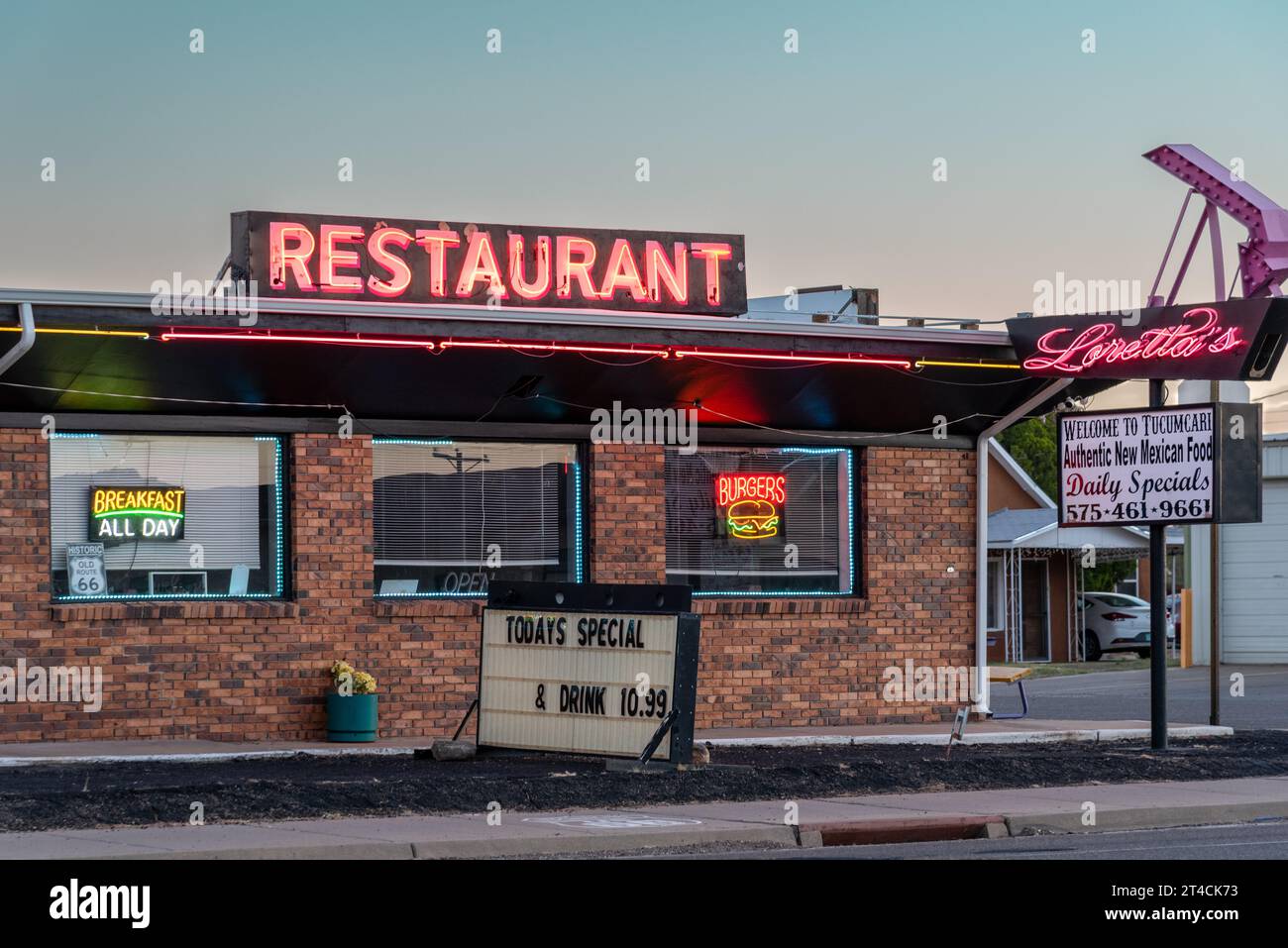 Loretta's Restaurant, edificio in mattoni a un piano con insegne al neon illuminate, la mattina presto, sulla Route 66, Tucumcari, Quay County, New Mexico, Stati Uniti. Foto Stock