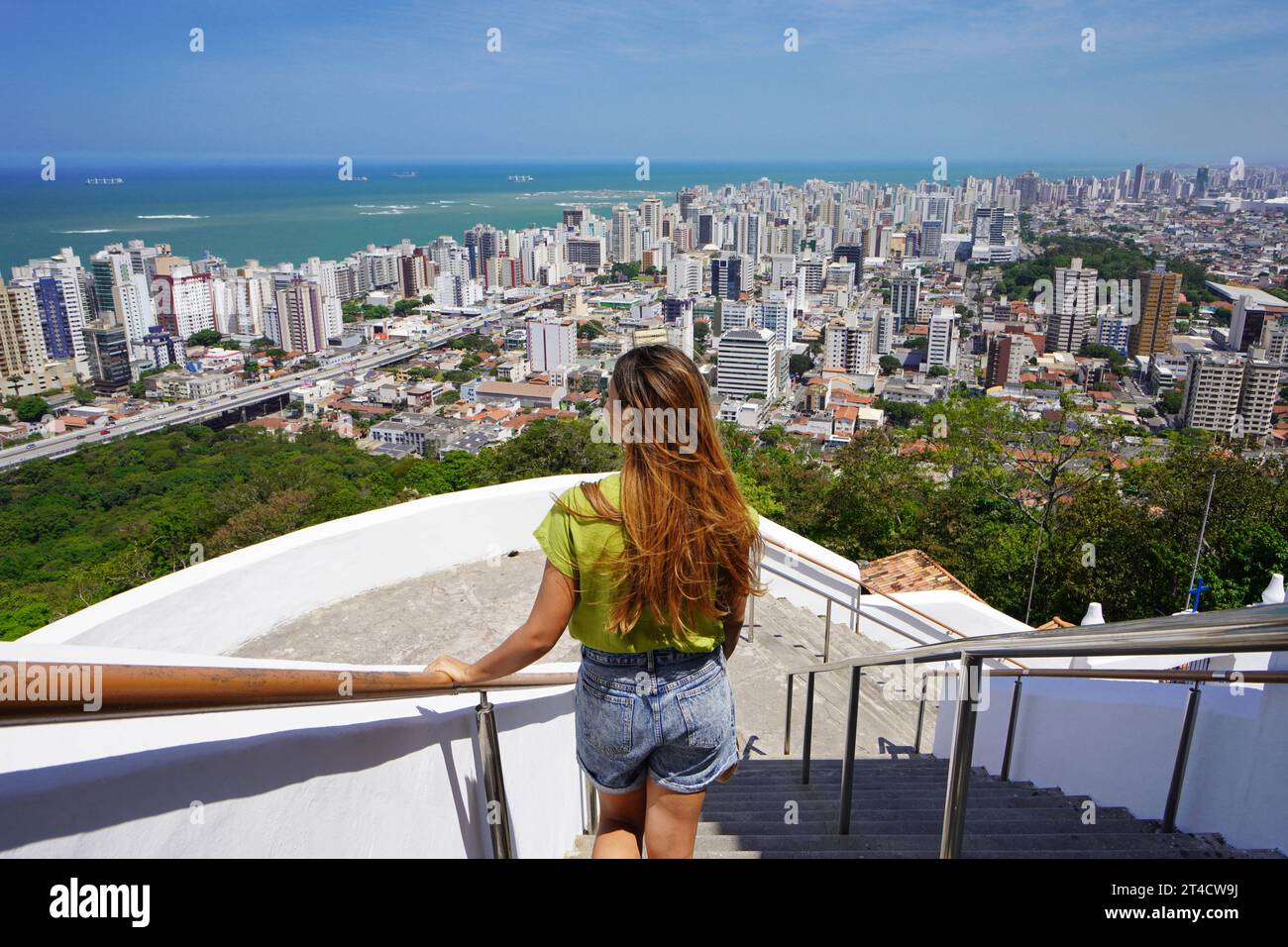 Vacanze in Brasile. Vista posteriore della bellissima ragazza della moda che si gode la vista della regione metropolitana di Vitoria, Espirito Santo, Brasile. Foto Stock