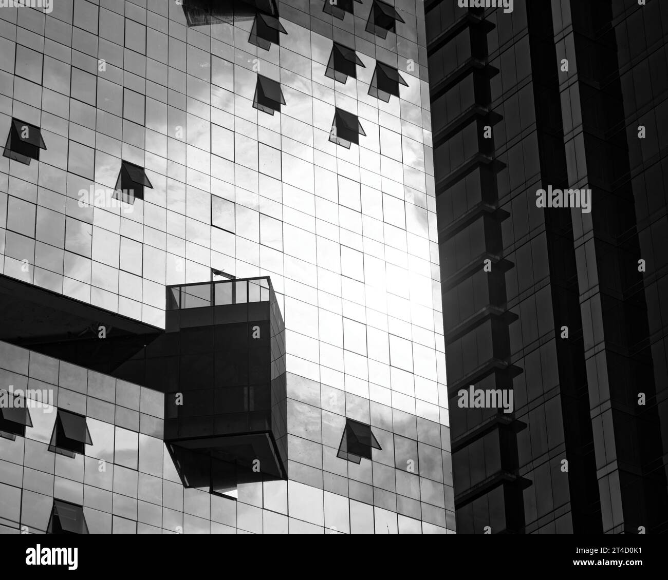 Una cattura monocromatica della facciata di un edificio contemporaneo, che mette in risalto il motivo a griglia simmetrico delle finestre con infissi irregolari, la pronunciata r Foto Stock