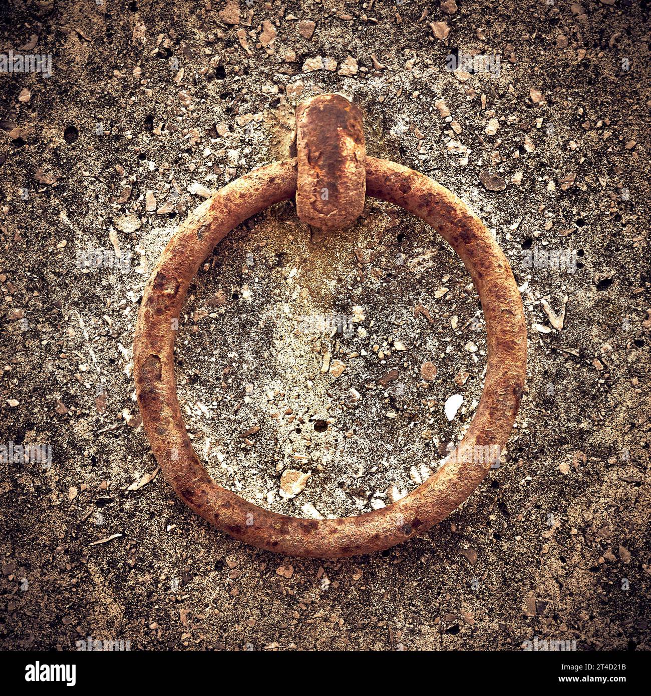 Anello in metallo arrugginito fissato a una parete di cemento Foto Stock