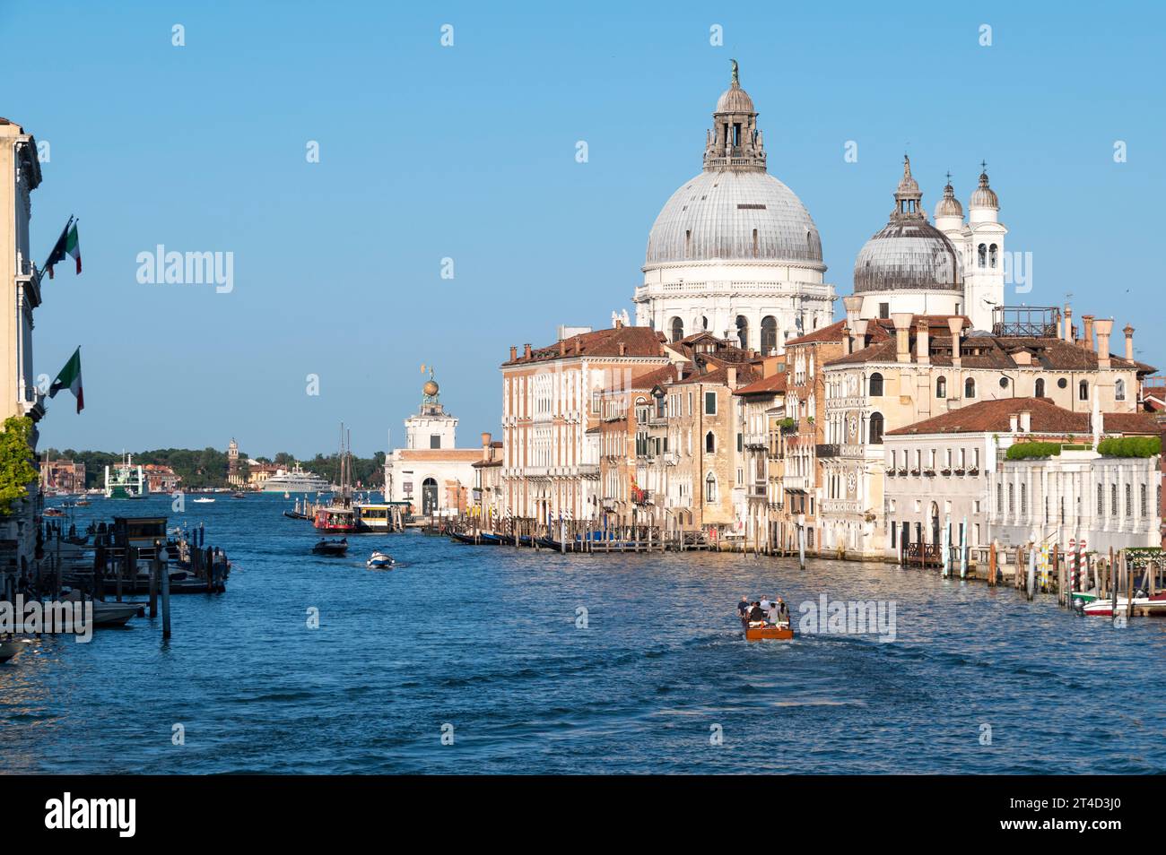 Immersa nella luce del sole della prima sera d'estate sugli edifici rinascimentali lungo il Canal grande a Venezia, nella regione Veneto dell'Italia settentrionale. Il pozzo Foto Stock