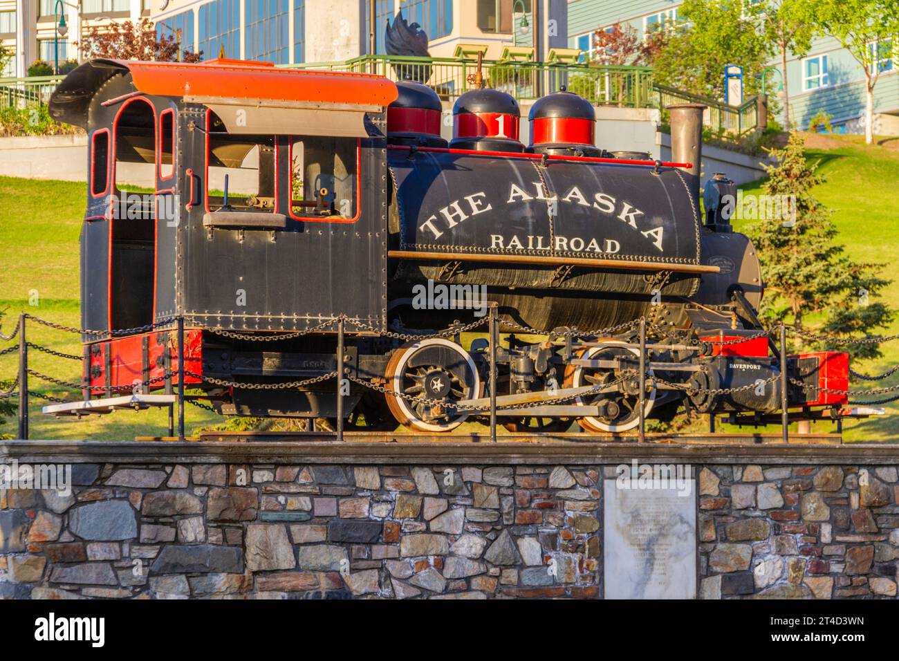 Alaska Railroad treno storico statua con centro di Anchorage Hotel in background. Foto Stock